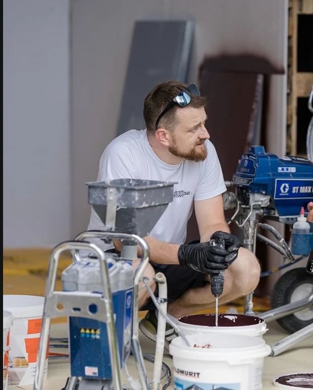 Marcin przy agregacie przygotowuje materiał do natrysku